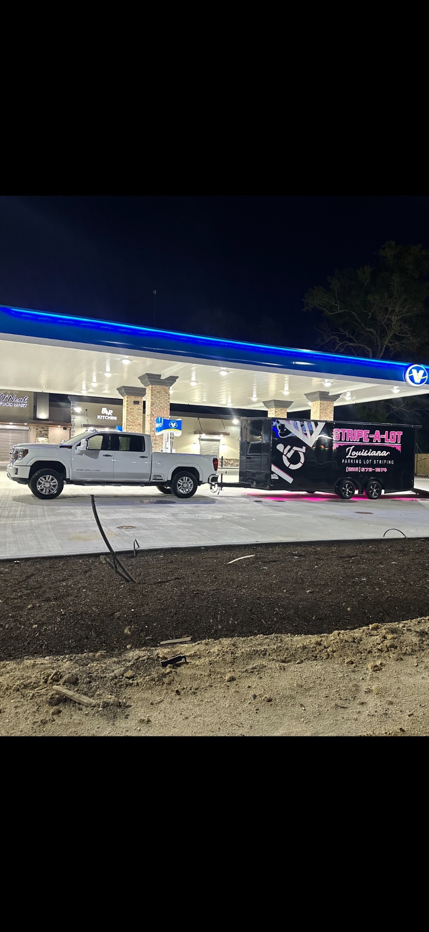 Stripe-A-Lot Louisiana truck and equipment trailer at a nighttime project